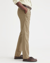 Side view of model wearing British Khaki Men's Slim Fit Smart 360 Flex Workday Khaki Pants.