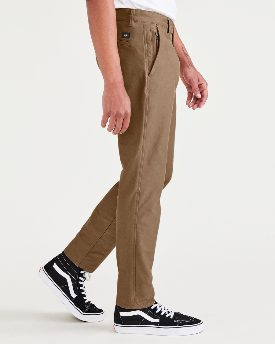 Side view of model wearing Cub Men's Skinny Fit Smart 360 Knit Chino Pants.