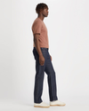 Side view of model wearing Dark Indigo Rinse Big and Tall Tapered Fit Original Jean Cut Pants.