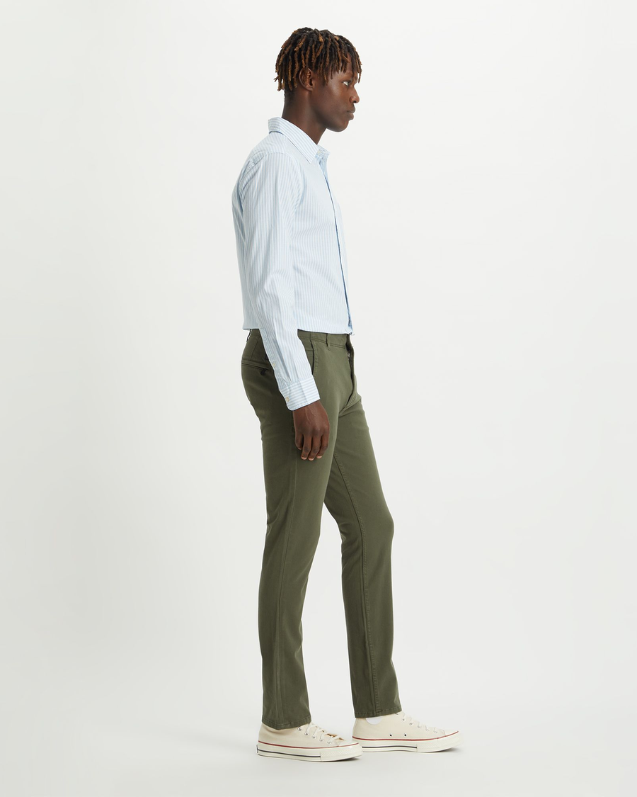 Side view of model wearing Dockers Olive Men's Skinny Fit Smart 360 Flex Alpha Khaki Pants.