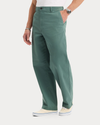 Side view of model wearing Duck Green Eighty-Six Original Chino Pants, Loose Fit.