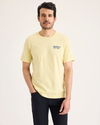 Front view of model wearing Dusty Yellow Men's Slim Fit Logo Tee.