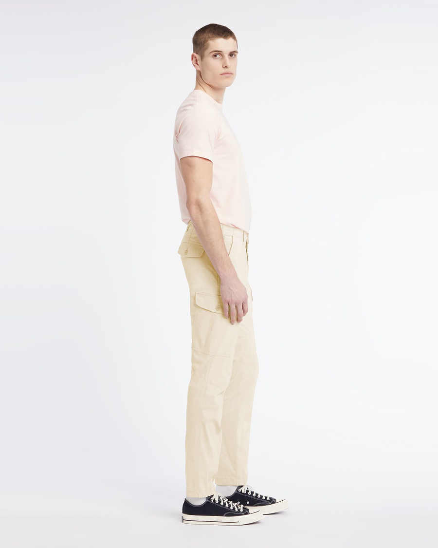 Side view of model wearing Egret Men's Slim Tapered Fit Cargo Pants.