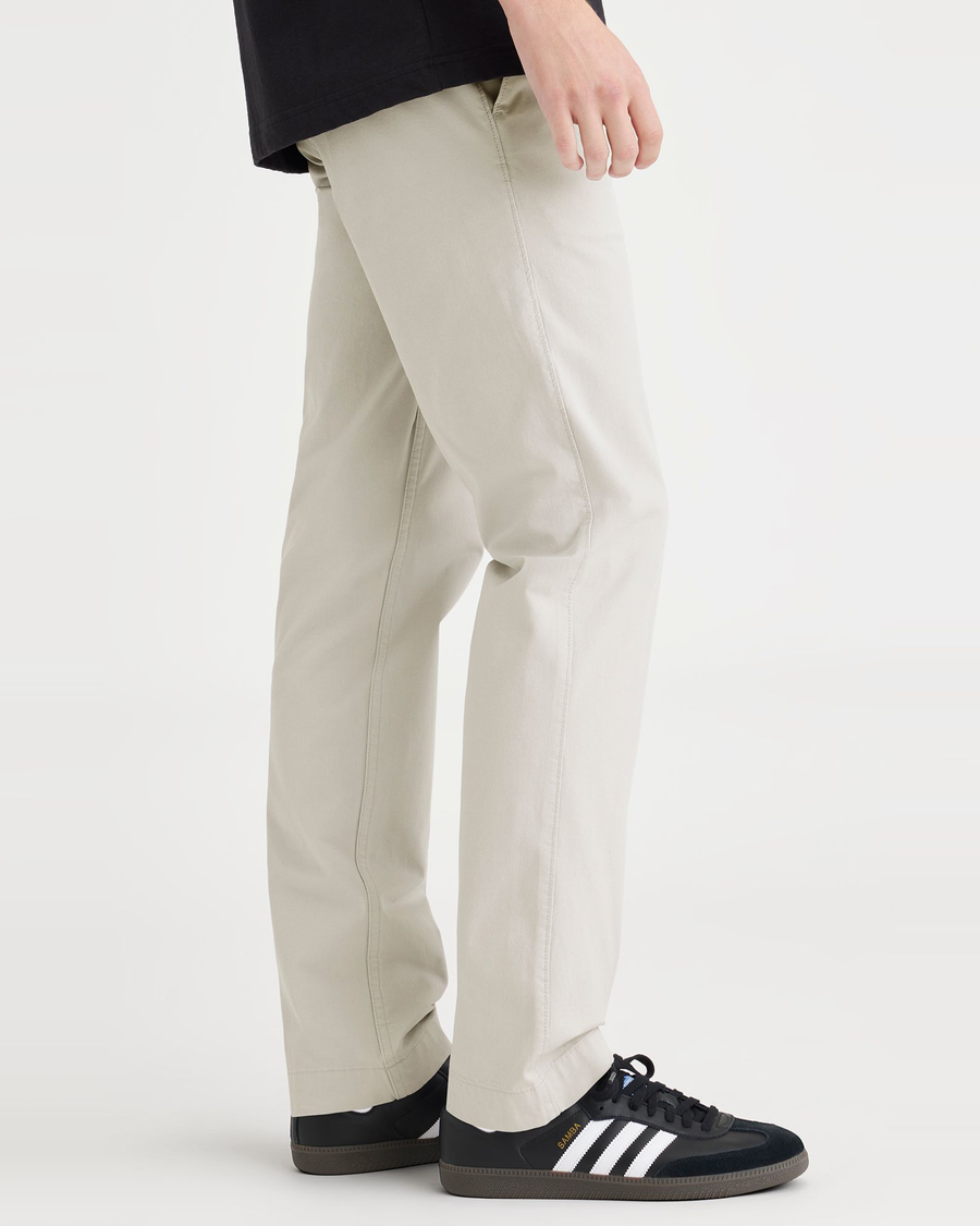 Side view of model wearing Grit Men's Slim Fit Smart 360 Flex California Chino Pants.
