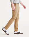 Side view of model wearing Harvest Gold Men's Skinny Fit Smart 360 Flex California Chino Pants.