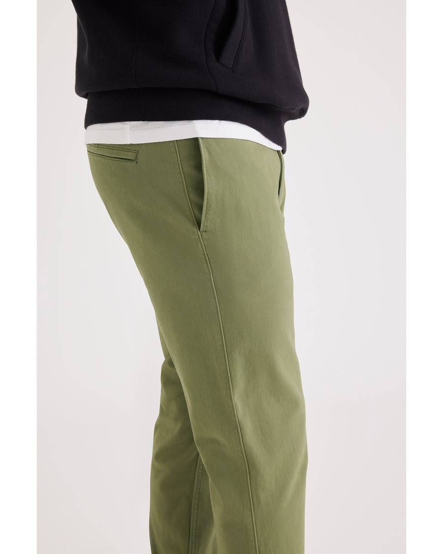 Side view of model wearing Loden Green Alpha Chino Pants, Skinny Fit.