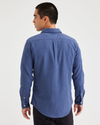 Back view of model wearing Medium Blue Heather Men's Slim Fit Icon Button Up Shirt.