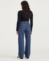 Back view of model wearing Medium Indigo Stonewash Women's Relaxed Fit Mid-Rise Jeans.