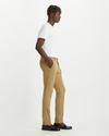 Side view of model wearing New British Khaki Men's Skinny Fit Supreme Flex Alpha Khaki Pants.