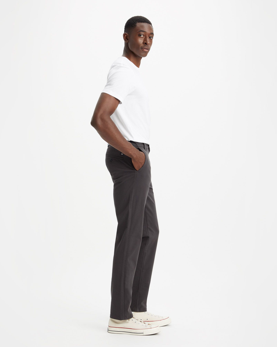 Side view of model wearing Steelhead Men's Slim Fit Supreme Flex Alpha Khaki Pants.