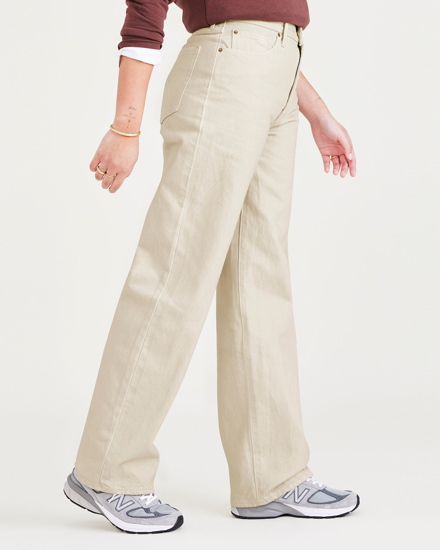 Side view of model wearing Tan Garment Dye Women's Relaxed Fit Mid-Rise Jeans.